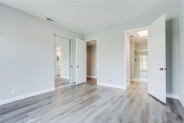 unfurnished bedroom featuring light hardwood / wood-style flooring and a closet