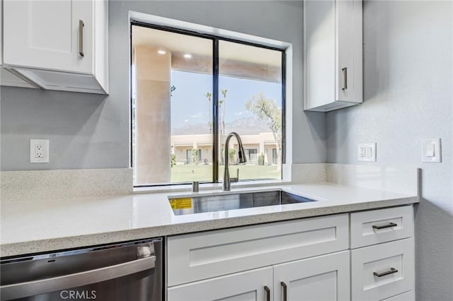 kitchen with white cabinets, dishwasher, and sink