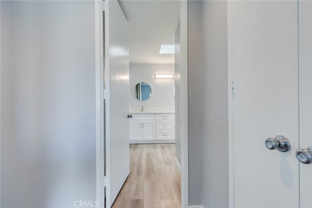 hall featuring light hardwood / wood-style floors and sink