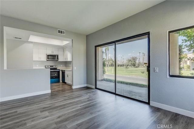 unfurnished living room with hardwood / wood-style flooring and a healthy amount of sunlight