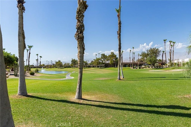 view of property's community featuring a lawn and a water view