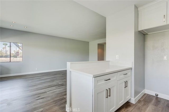 kitchen featuring kitchen peninsula, white cabinetry, and dark hardwood / wood-style flooring