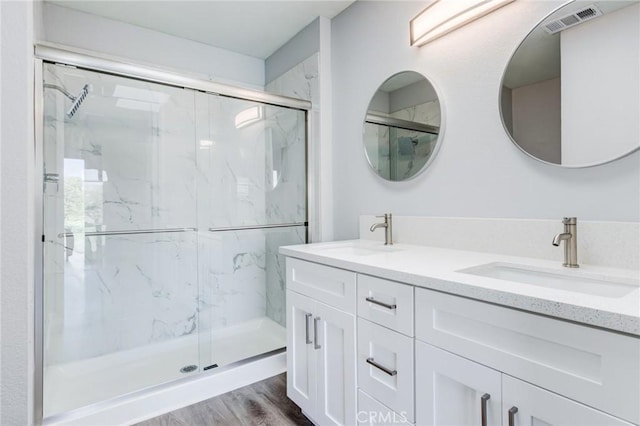 bathroom featuring hardwood / wood-style floors, vanity, and a shower with shower door