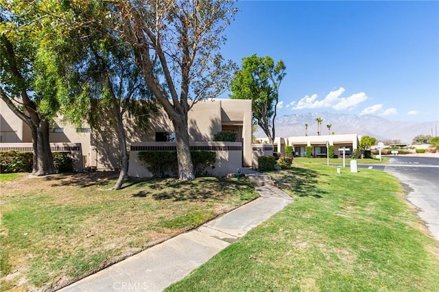 view of front of home with a mountain view and a front yard