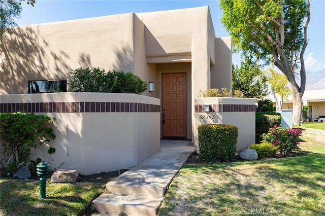 property entrance with a lawn