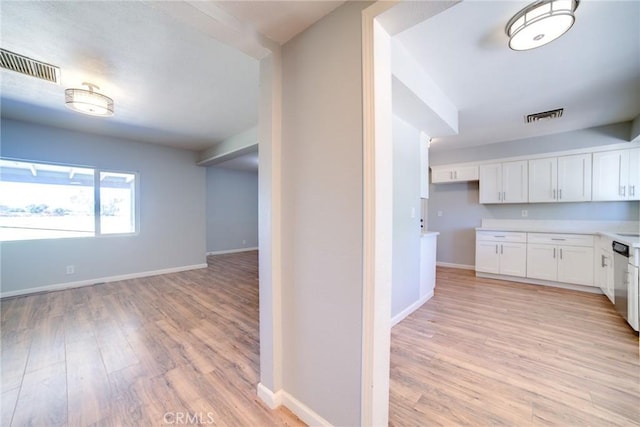 kitchen with white cabinets, light hardwood / wood-style flooring, and dishwasher