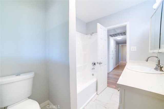 full bathroom with hardwood / wood-style flooring, vanity, tub / shower combination, and toilet