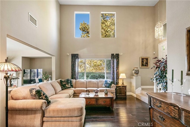 living room with a high ceiling and dark hardwood / wood-style flooring