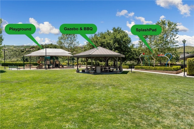 view of community with a playground, a gazebo, and a lawn