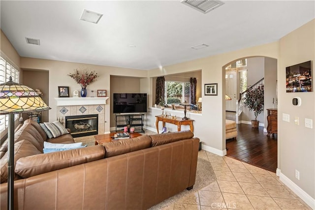 living room with light tile patterned floors and a fireplace