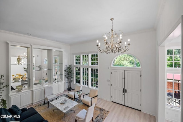 foyer with a chandelier, light hardwood / wood-style flooring, and crown molding