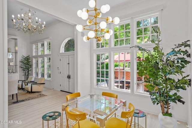 dining space featuring an inviting chandelier and light hardwood / wood-style flooring