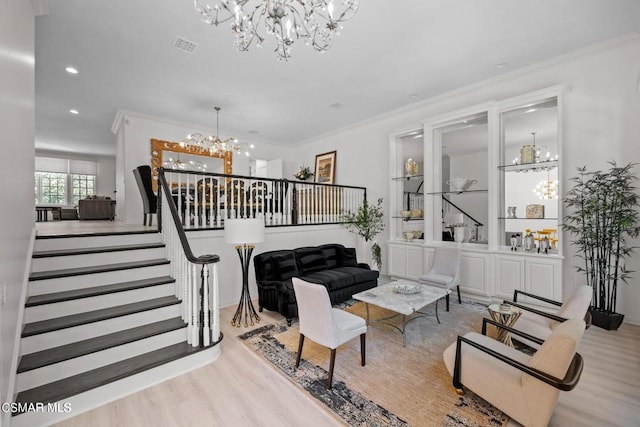 living room featuring a chandelier, crown molding, and light hardwood / wood-style floors