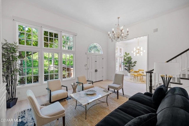 living room featuring plenty of natural light, a chandelier, and light hardwood / wood-style flooring