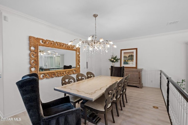 dining area with a chandelier, light hardwood / wood-style floors, and ornamental molding