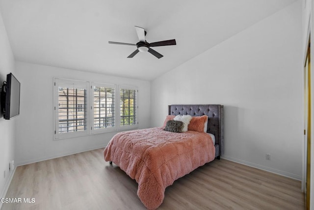 bedroom with ceiling fan, light hardwood / wood-style flooring, and vaulted ceiling