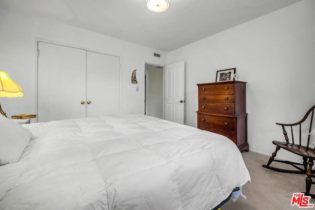 bedroom featuring light colored carpet and a closet