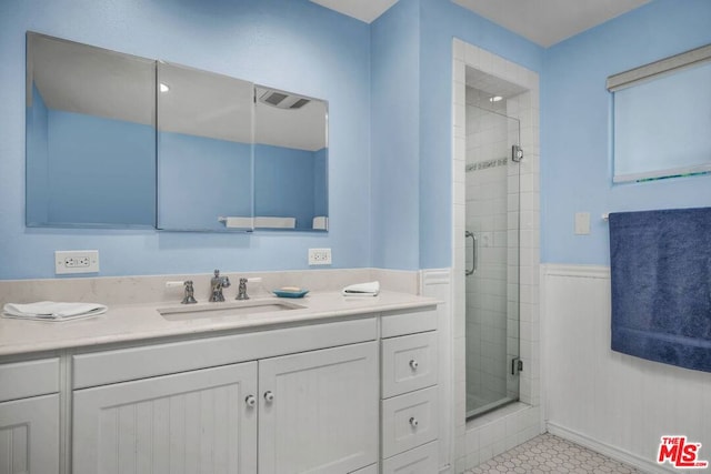 bathroom featuring vanity, tile patterned floors, and a shower with door