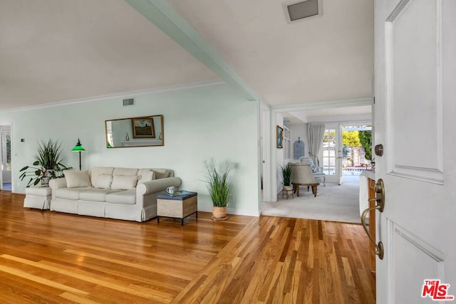 living room featuring hardwood / wood-style flooring, ornamental molding, and french doors