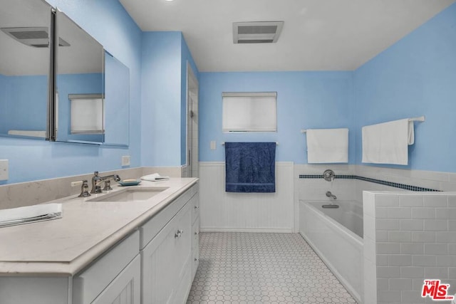 bathroom with a washtub and vanity