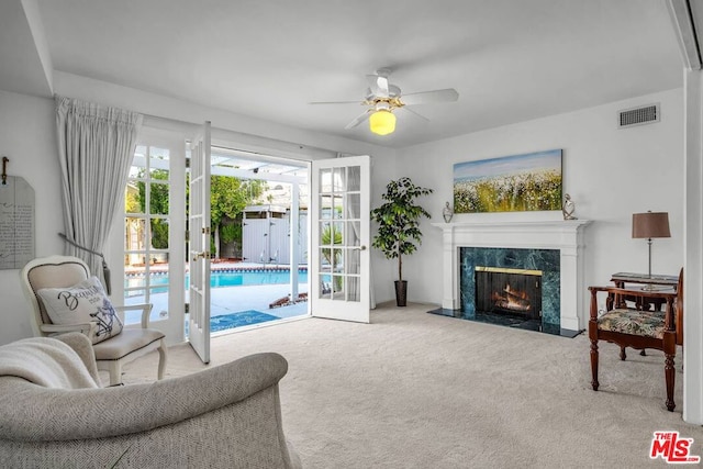 living room with light carpet, ceiling fan, and a fireplace