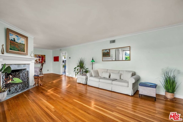 living room featuring a premium fireplace, hardwood / wood-style floors, and ornamental molding