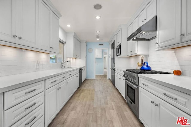 kitchen featuring white cabinets, sink, appliances with stainless steel finishes, and light hardwood / wood-style flooring