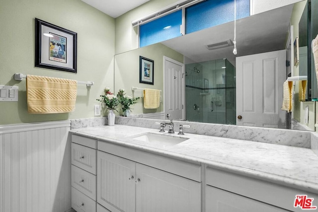 bathroom with vanity and a shower with shower door