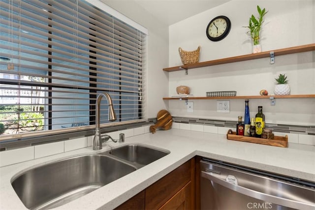 kitchen with tasteful backsplash, sink, and stainless steel dishwasher