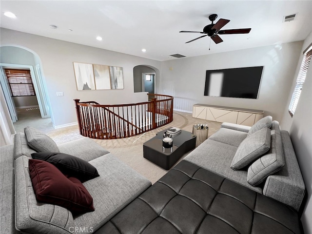 carpeted living room with ceiling fan