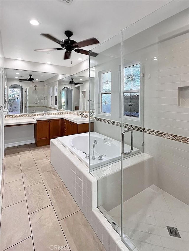 bathroom with plus walk in shower, vanity, ceiling fan, and tile patterned flooring