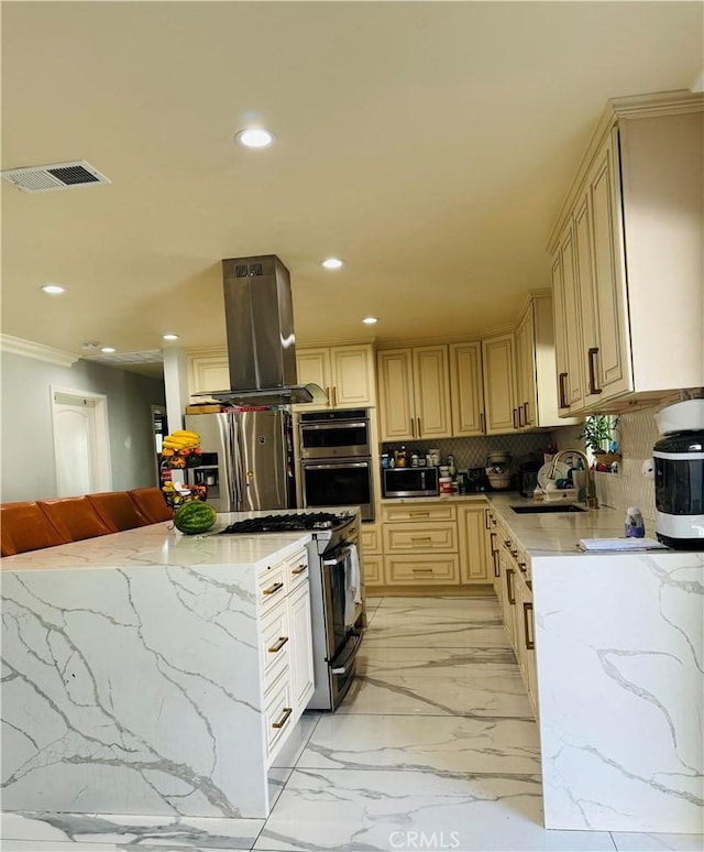 kitchen with backsplash, light stone counters, stainless steel appliances, island range hood, and sink