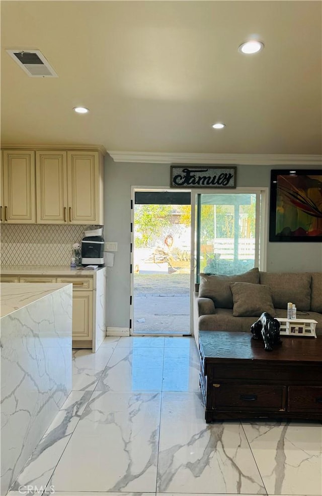 interior space featuring cream cabinetry, crown molding, and tasteful backsplash