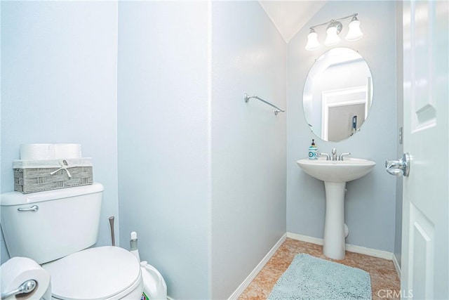 bathroom featuring lofted ceiling and toilet