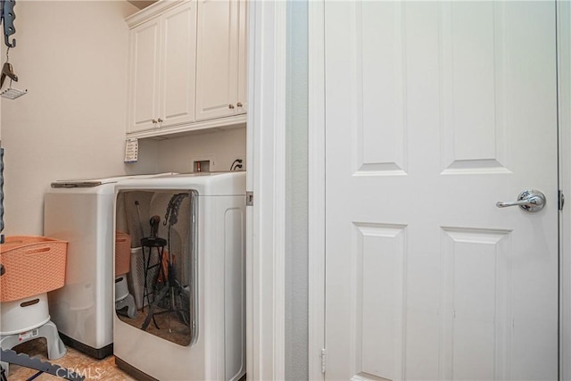 washroom with cabinets and washer and clothes dryer