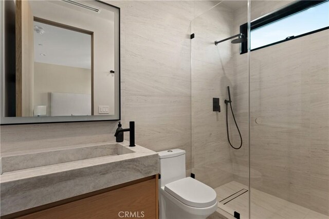 bathroom featuring vanity, toilet, and a shower with shower door