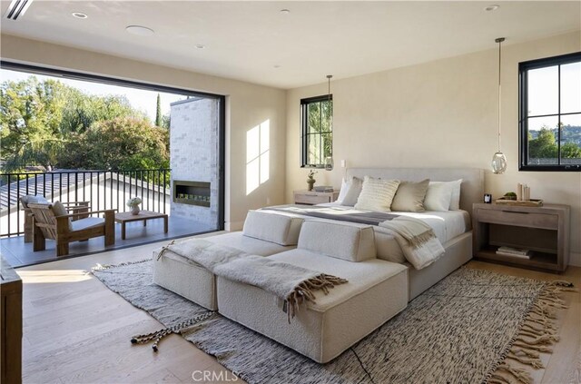 bedroom with hardwood / wood-style floors and access to outside