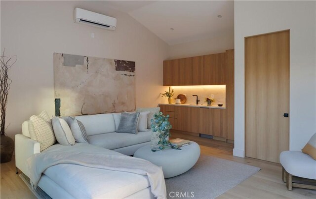 living room featuring light wood-type flooring, lofted ceiling, and a wall unit AC