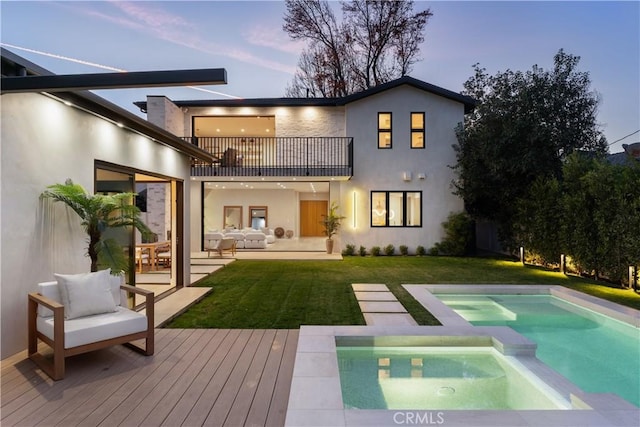 back house at dusk featuring an outdoor hangout area, a swimming pool with hot tub, a balcony, a yard, and a patio