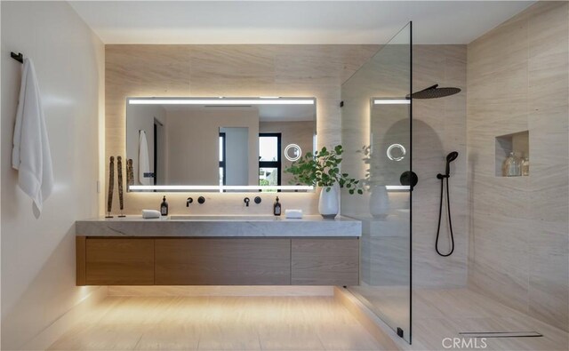 bathroom with vanity and a tile shower