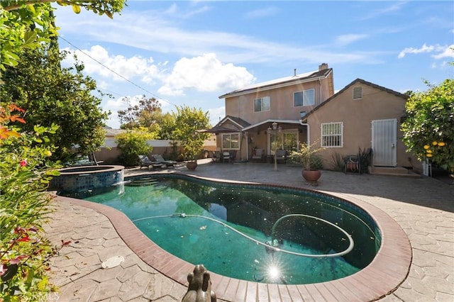 view of pool with a patio area and an in ground hot tub