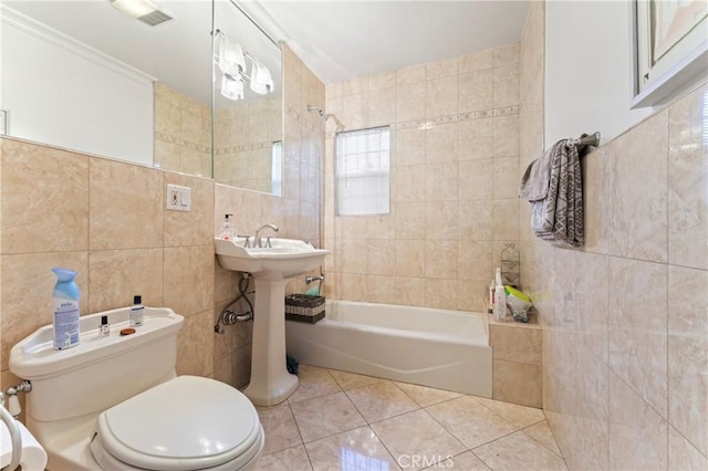 full bathroom with  shower combination, tile patterned floors, sink, toilet, and tile walls