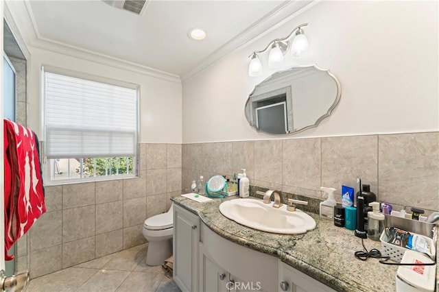 bathroom with tile patterned floors, toilet, vanity, tile walls, and ornamental molding