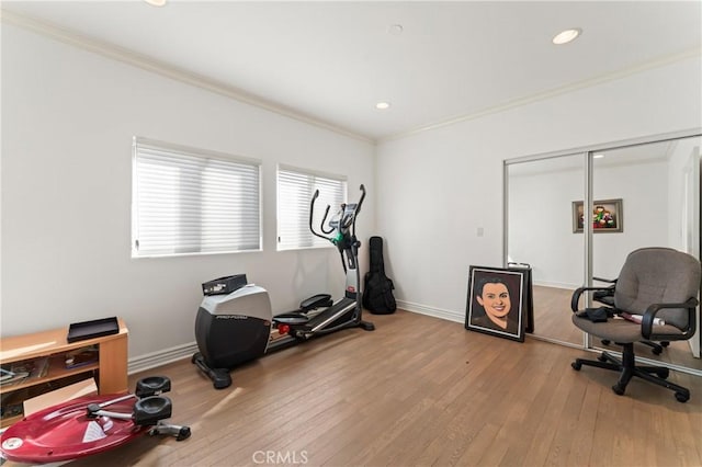 workout area featuring hardwood / wood-style flooring and crown molding