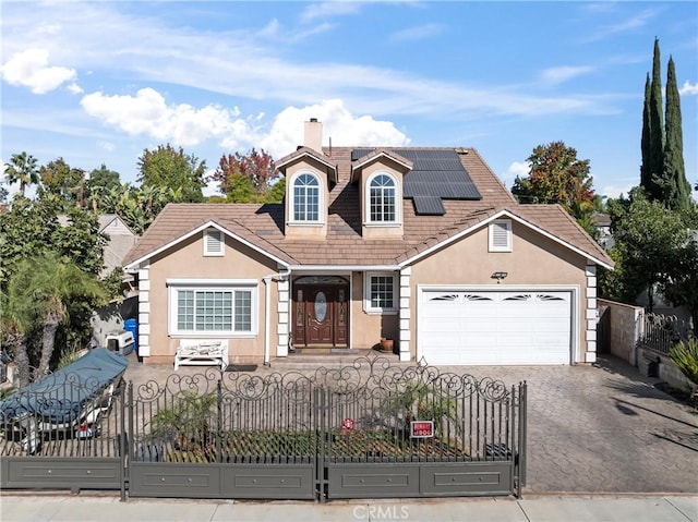 view of front of property featuring a garage and solar panels