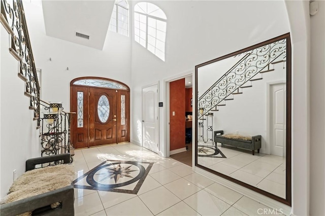 foyer entrance featuring light tile patterned flooring and a high ceiling