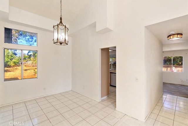 1520 W Norwood St, Rialto, CA 92377 - spare room with light tile patterned flooring, a towering ceiling, baseboards, and a notable chandelier