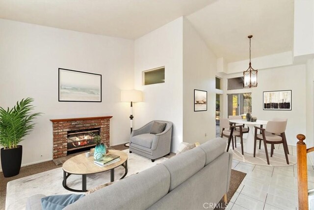 living room with a fireplace, light tile patterned floors, and a notable chandelier