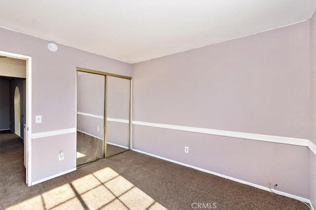 unfurnished bedroom featuring carpet and a closet