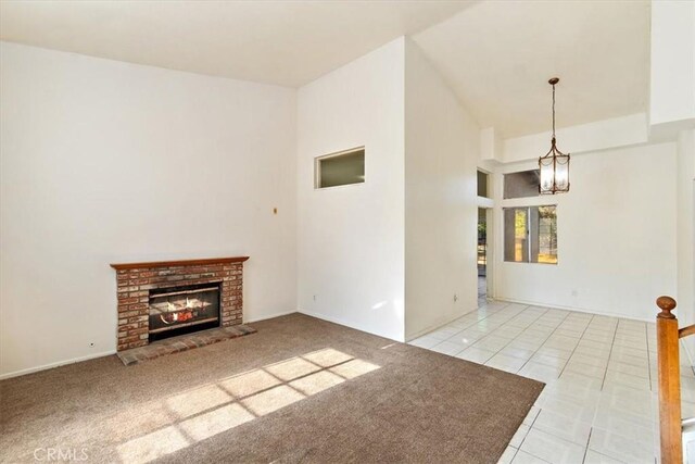 unfurnished living room with a fireplace, light tile patterned flooring, and an inviting chandelier